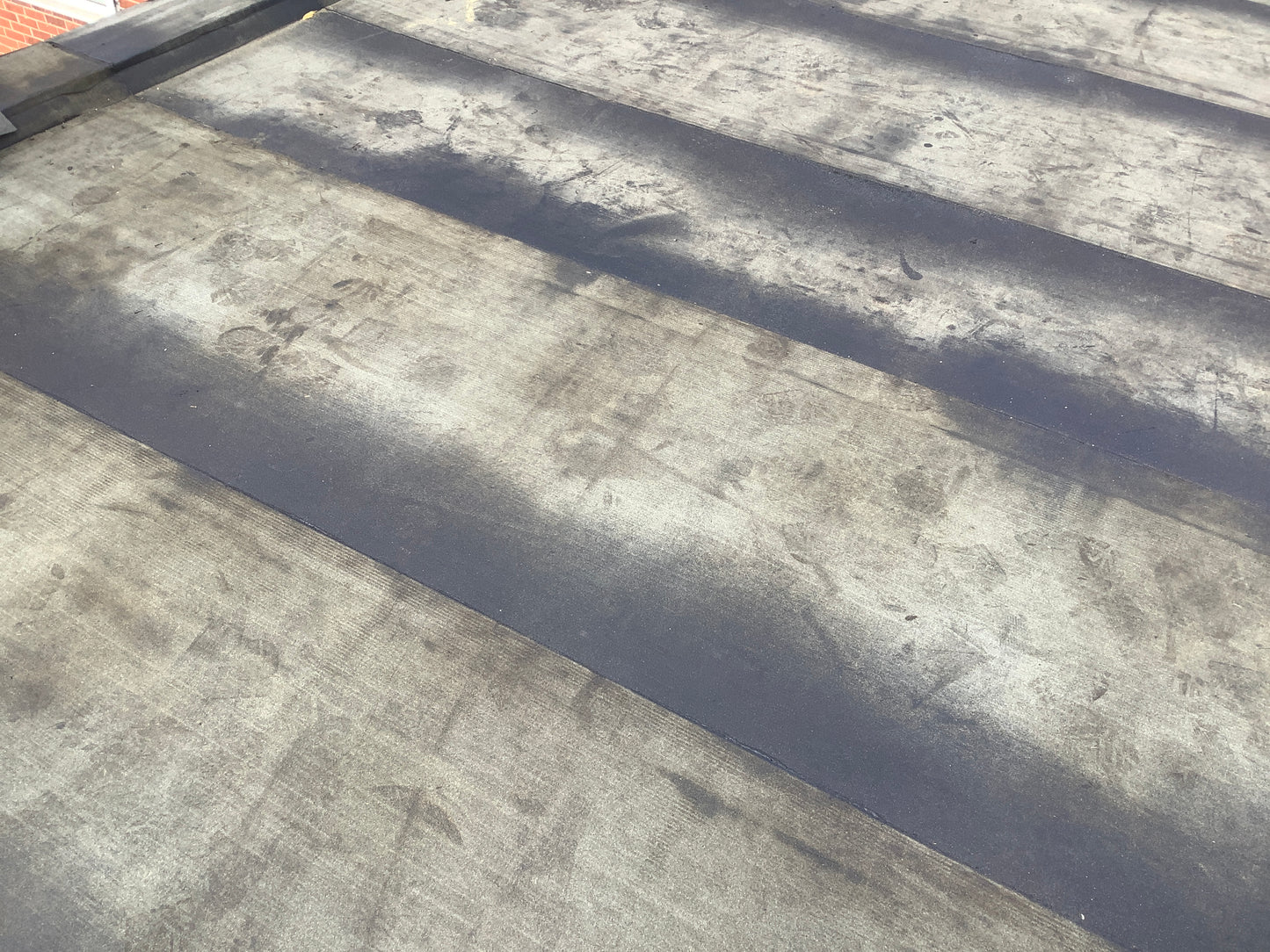 Installed bituminous roofing membrane within flat roof waterproofing system with a sand finish torch applied