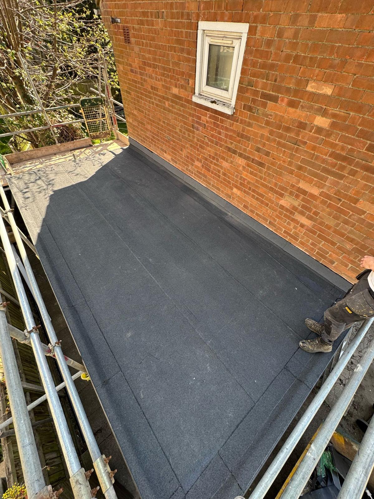Installed bituminous roofing membrane within flat roof waterproofing system