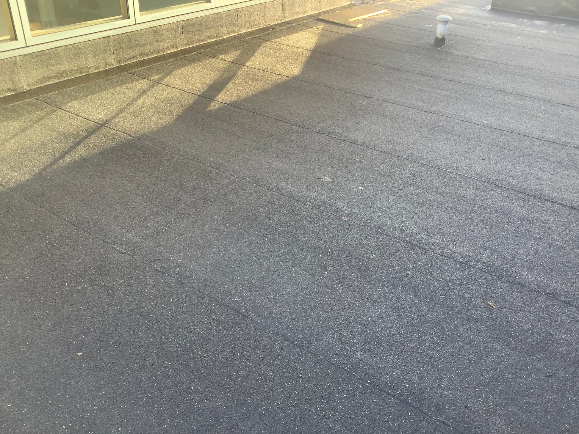 Installed bituminous roofing membrane within flat roof waterproofing system