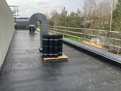 Torch-applied roofing membrane rolls positioned on a commercial flat roof project