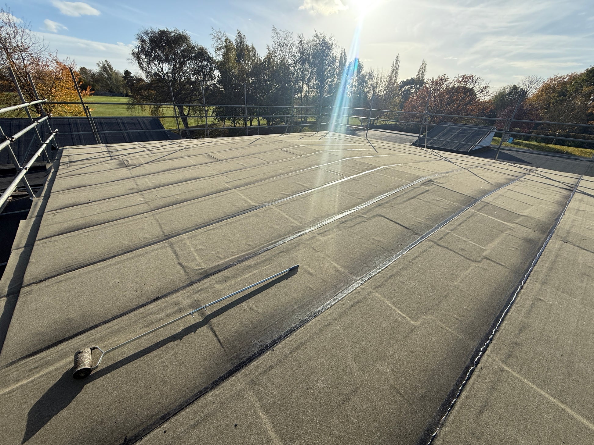 Installed self adhesive bituminous roofing membrane within flat roof waterproofing system