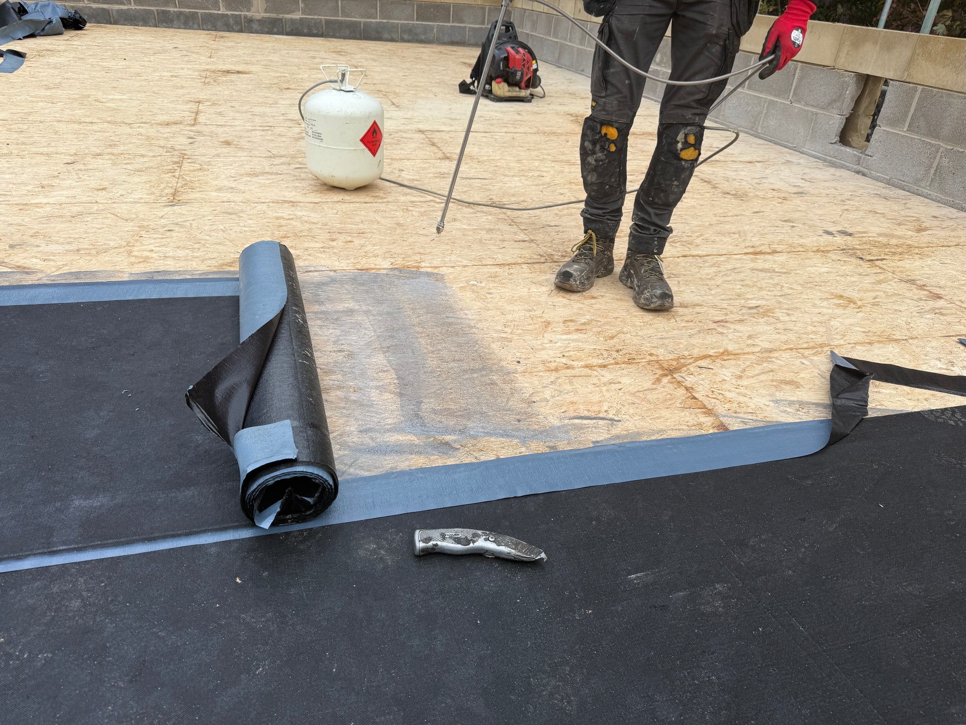 Installed self adhesive bituminous roofing membrane within flat roof system waterproofing