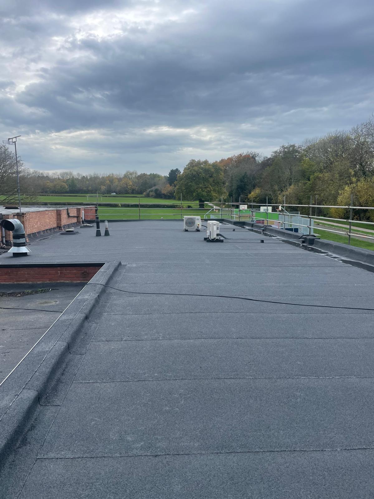 Installed bituminous roofing membrane within flat roof waterproofing system