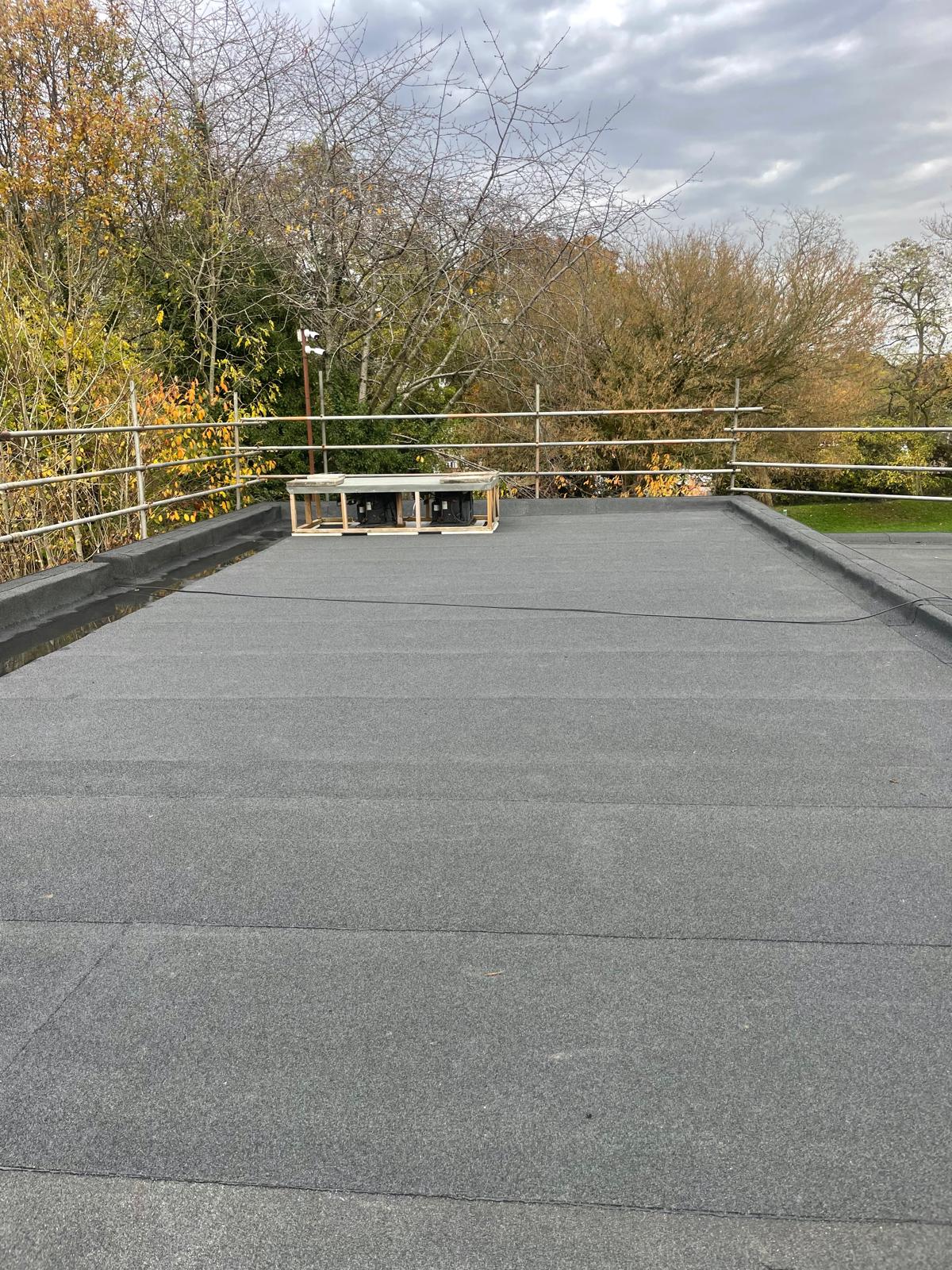 Installed bituminous roofing membrane within flat roof waterproofing system