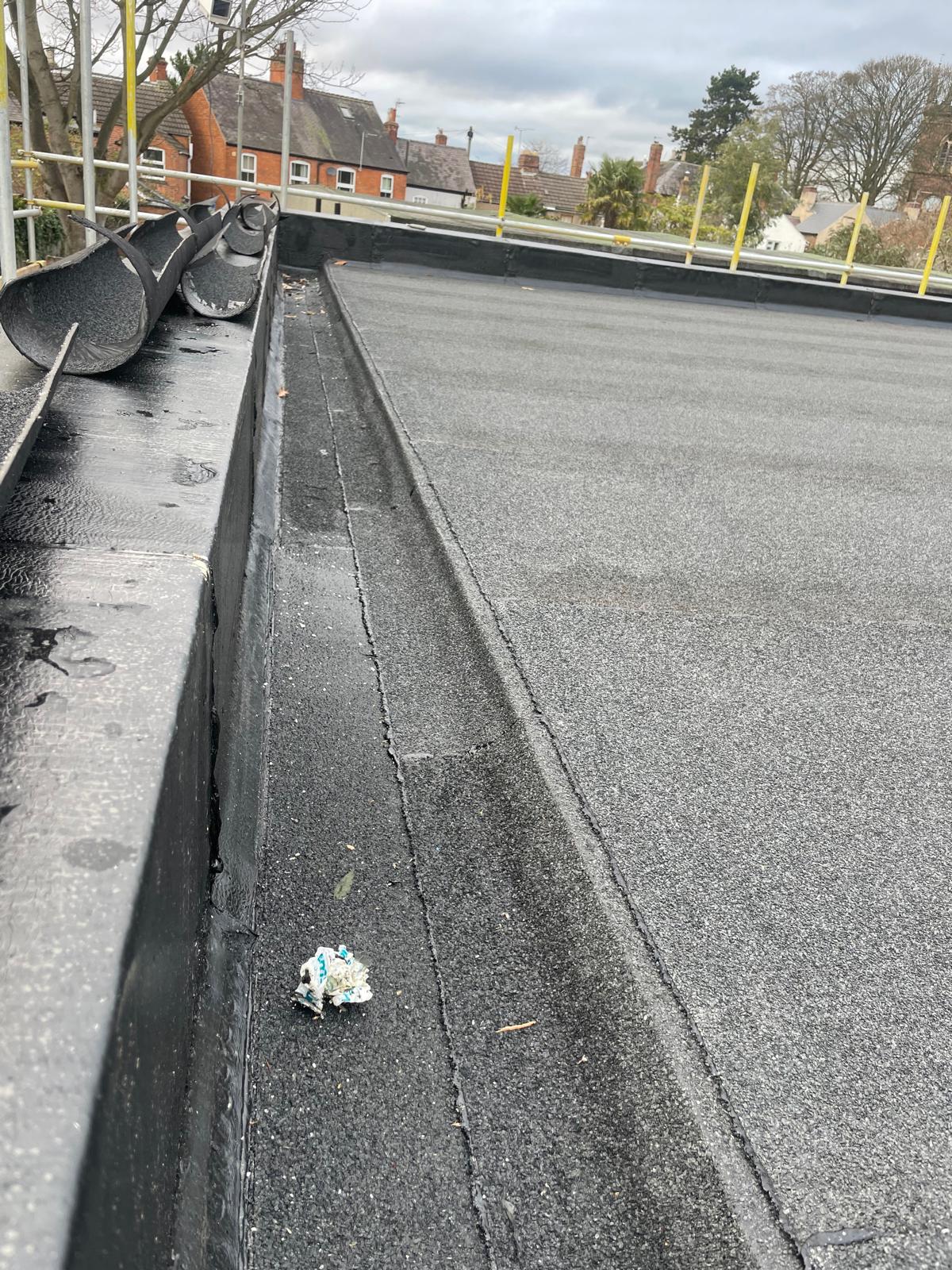 Installed bituminous roofing membrane within flat roof waterproofing system