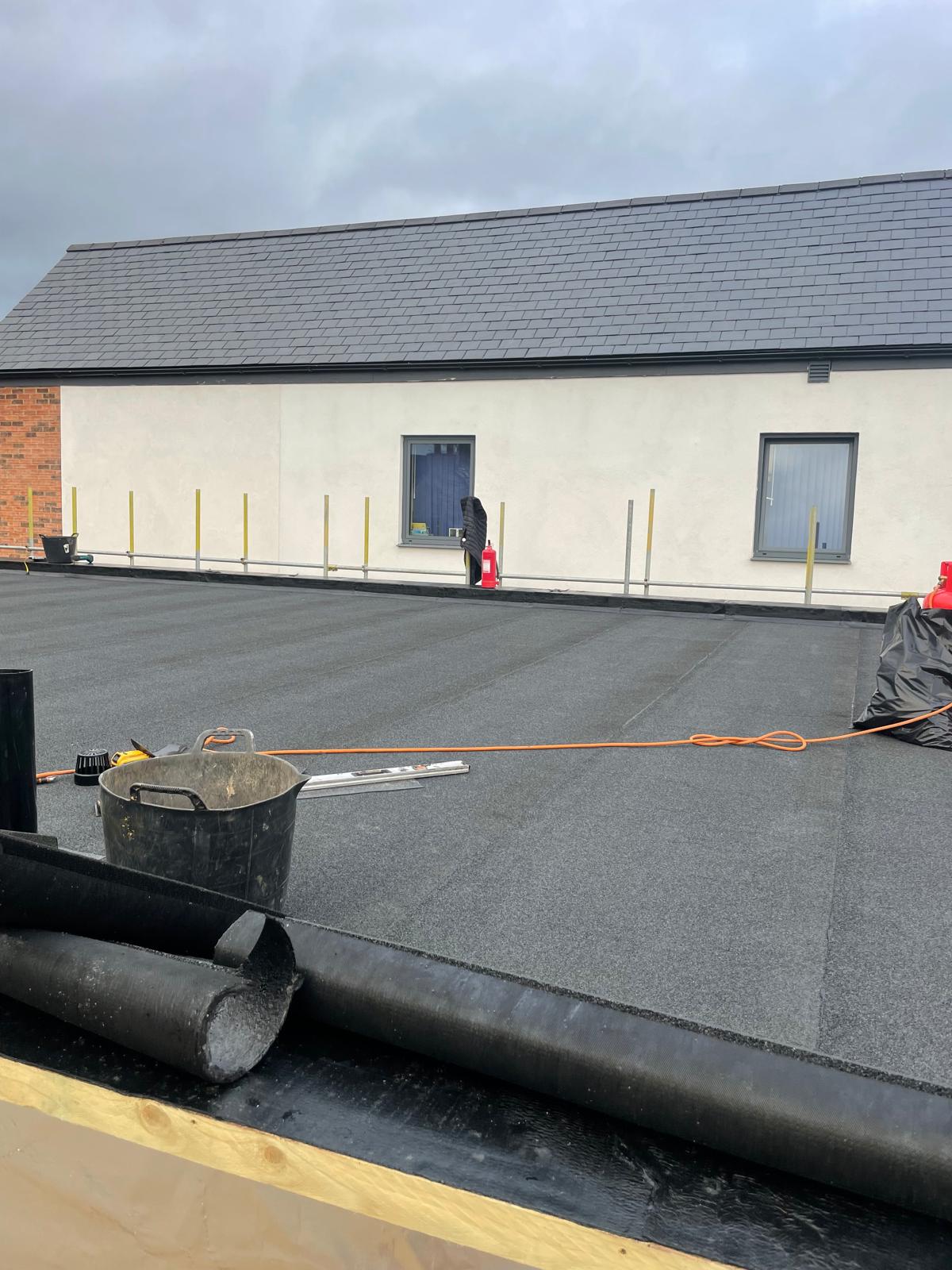 Installed bituminous roofing membrane within flat roof waterproofing system